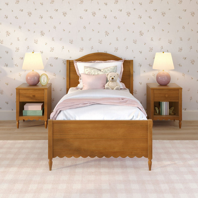 Cozy child's bedroom with wooden twin bed, soft pink bedding and pillows, teddy bear on the bed, floral wallpaper and matching pink lamps on wooden nightstands