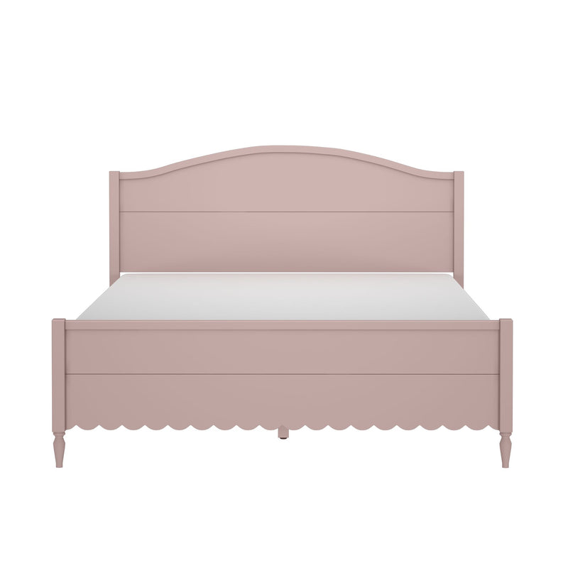 Blush pink wooden bed frame with arched headboard, scalloped footboard, turned legs and white mattress in cottage farmhouse style