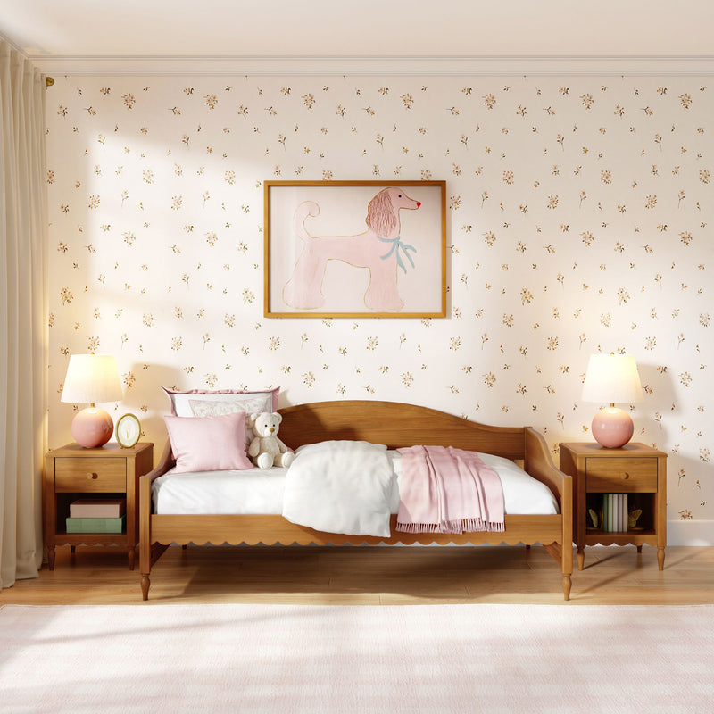 Pink girls' bedroom with wooden bed, floral wallpaper, framed poodle wall art, pastel pillows and throw, teddy bear and bedside lamps