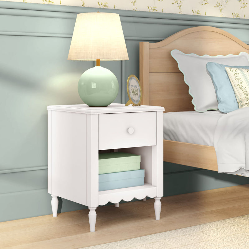 White nightstand bedside table with drawer and shelf, mint-green ceramic lamp, wooden bed frame and pastel pillows in cozy bedroom