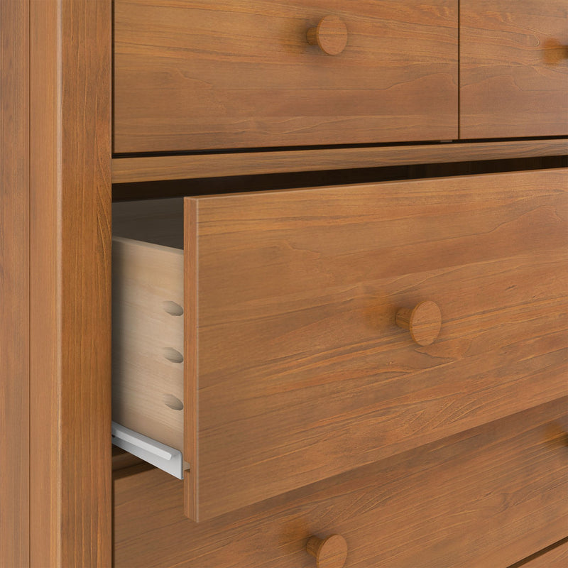 Close-up of solid wood dresser with partially open drawers showing dovetail joinery, maple wood grain finish, round wooden knobs and metal drawer slides