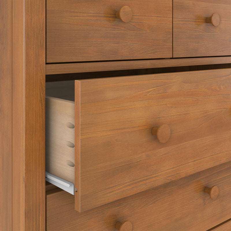 Solid wood dresser with a partially open drawer revealing dovetail joints and metal side-mounted slides in a warm natural wood finish.