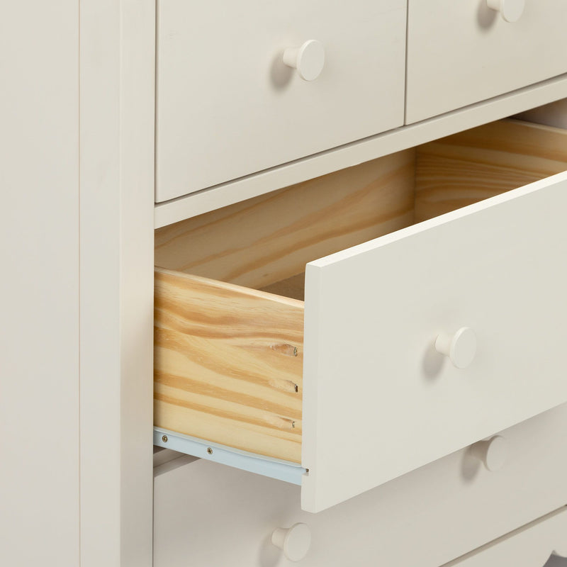White painted bedroom dresser with partially open drawers revealing natural pine interiors and round white knobs