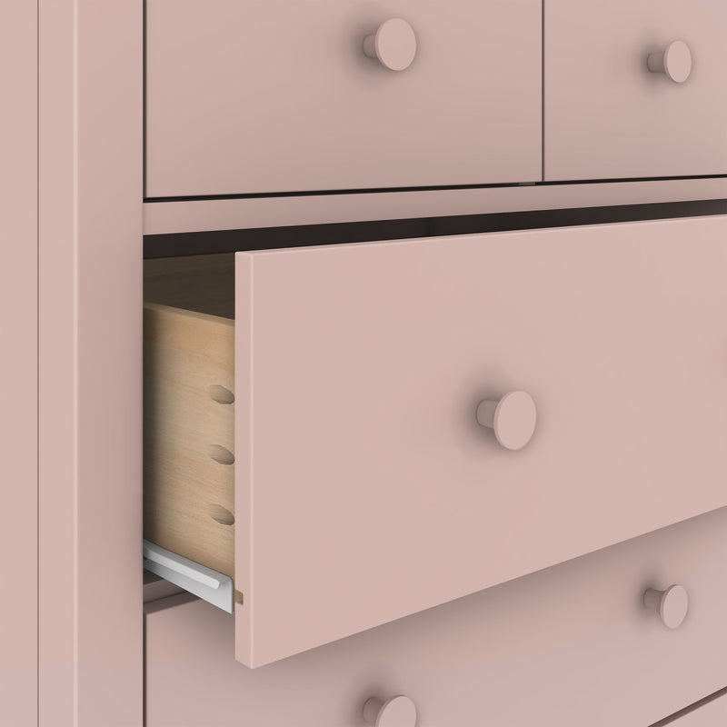 Close-up of pink painted dresser with partially open drawer showing dovetail joinery, round knobs and metal drawer slide for bedroom storage