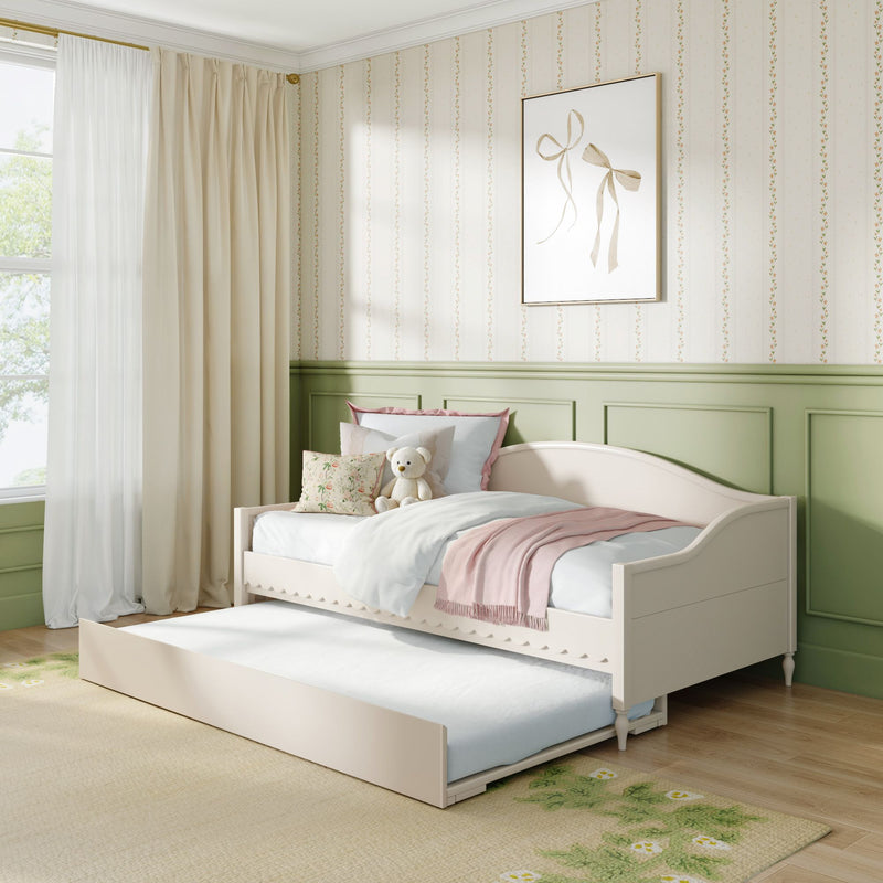 Pastel children's bedroom with daybed trundle, pink throw, floral pillows, teddy bear, cream curtains and green wainscoting