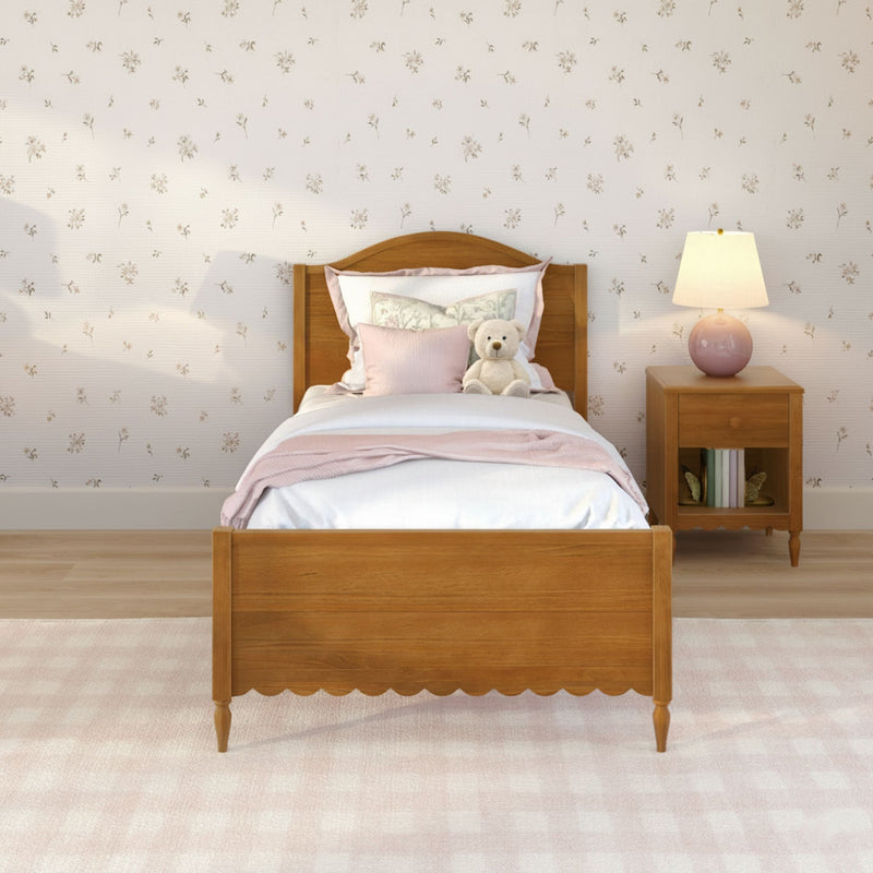 Cozy girls bedroom with wooden single bed, pink bedding and pillows, teddy bear, floral wallpaper and bedside lamp