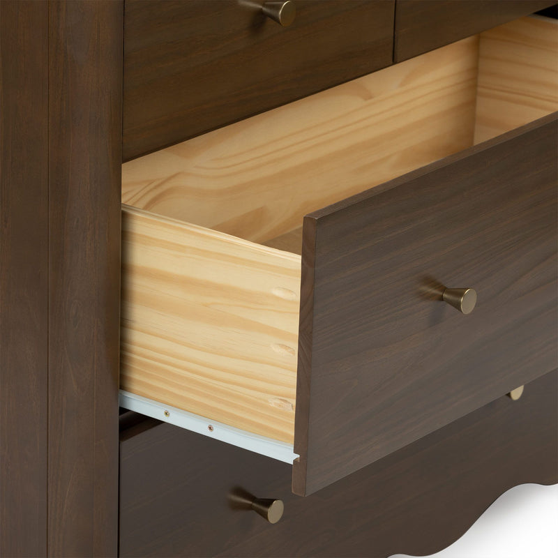 Close-up of dark wood dresser with an open light-wood drawer, brass knob and visible metal drawer slide highlighting wood grain and finish
