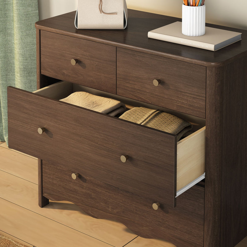 Walnut-finish wooden dresser chest of drawers with open drawer showing folded blankets, brass knobs, beige book and white vase on top