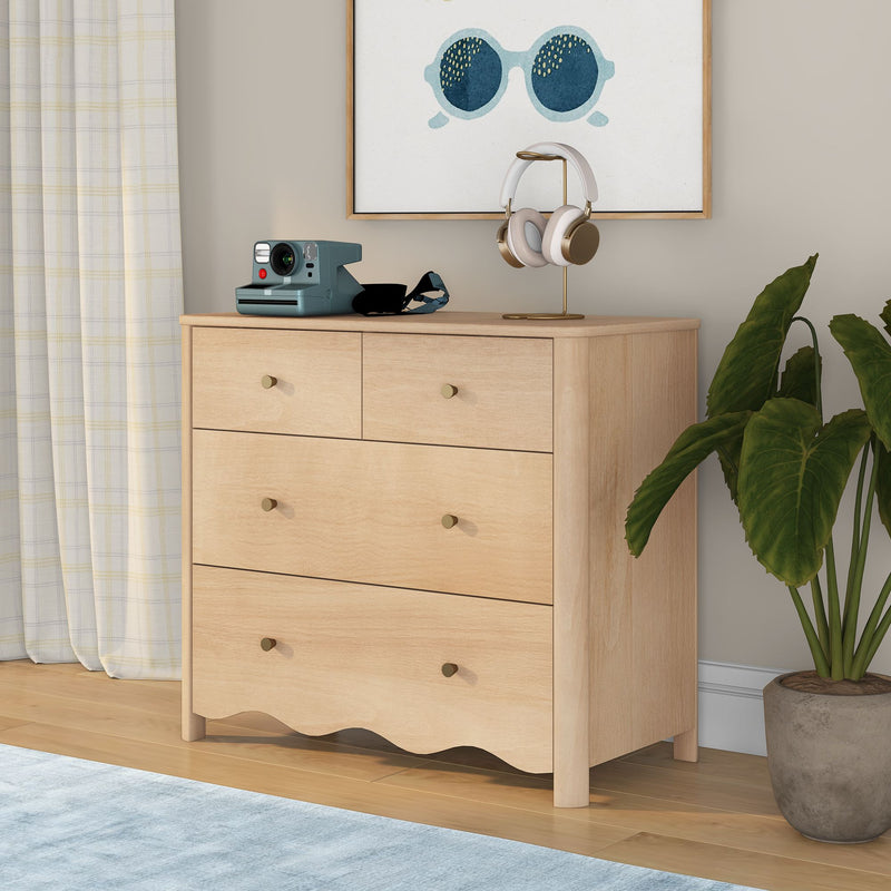 Light wood dresser with over-ear headphones on a gold stand, teal instant camera, sunglasses wall art and potted plant — modern bedroom decor