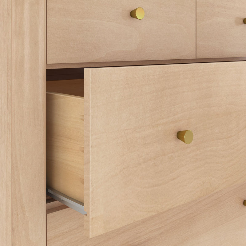 Light maple wood dresser with round brass knobs and a partially open drawer, modern bedroom storage