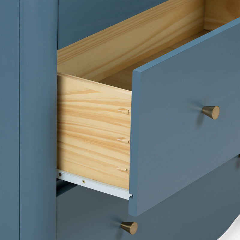 Close-up of blue painted dresser drawer with natural pine interior, brass knob and metal slide, modern bedroom furniture detail