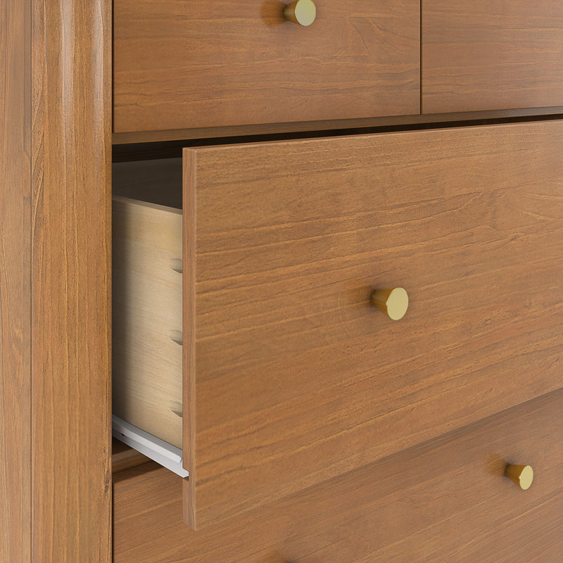 Solid wood dresser drawer close-up showing dovetail joints, warm wood grain finish and round brass knob