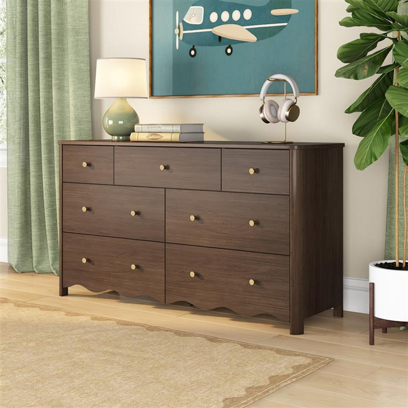 Mid-century walnut dresser with brass knobs, bedside lamp, headphone stand and teal airplane art in styled bedroom