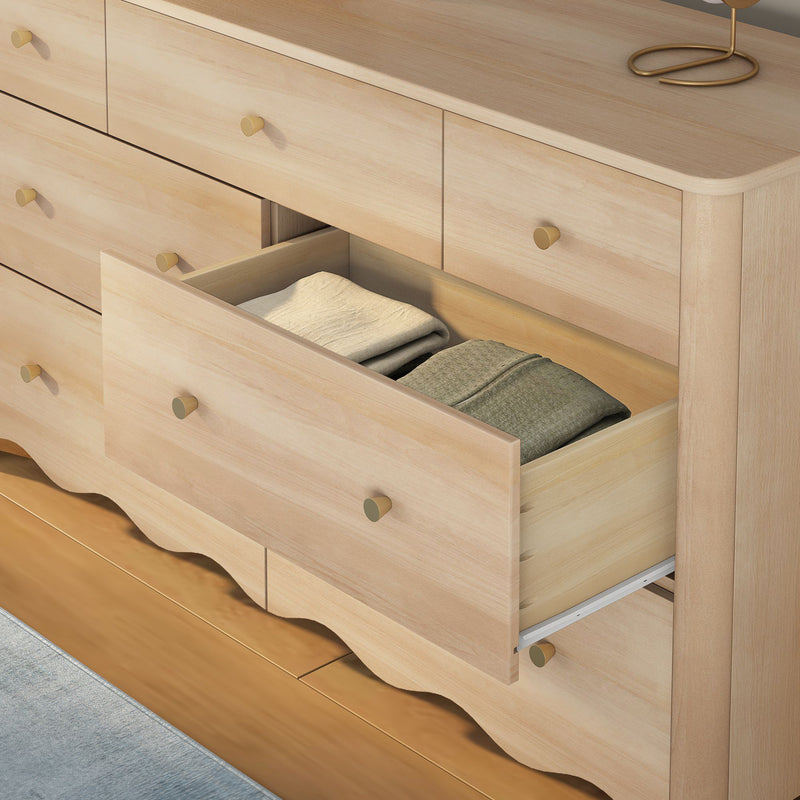 Light wood bedroom dresser with an open drawer showing neatly folded clothes, brass knobs and scalloped base—modern wooden chest of drawers for bedroom storage and organization