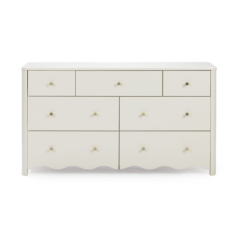 Off-white wooden dresser with multiple drawers, round brass knobs and scalloped base for bedroom storage