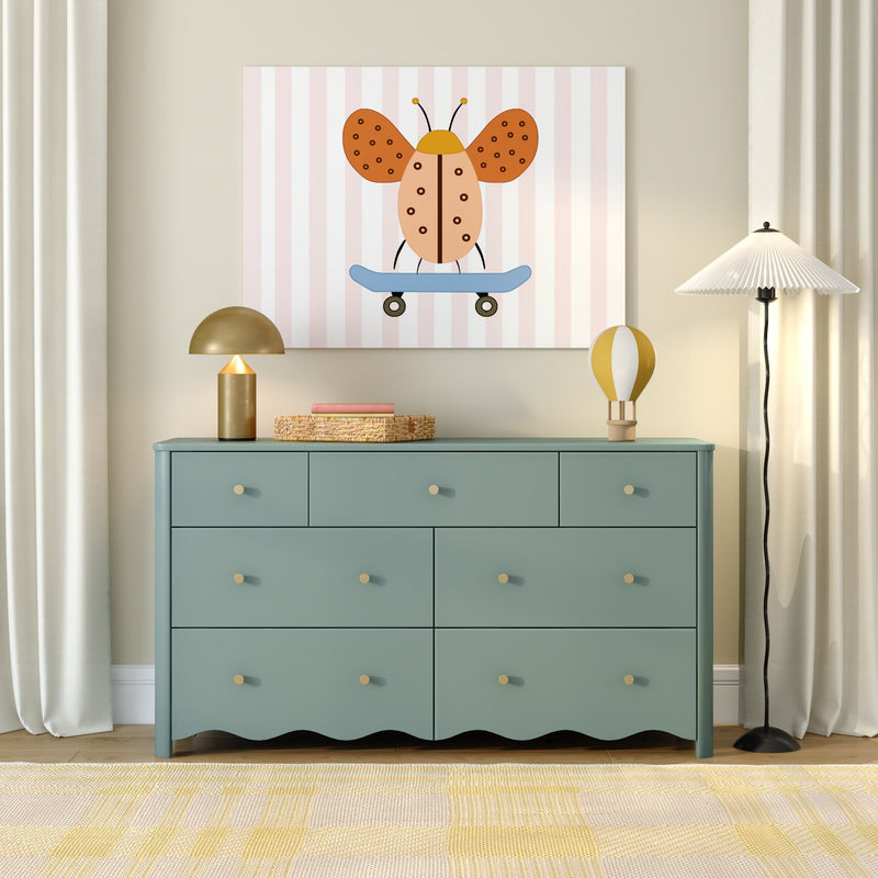 Teal dresser with six drawers in nursery, gold lamp, yellow rug and whimsical ladybug-on-skateboard wall art — kids room decor