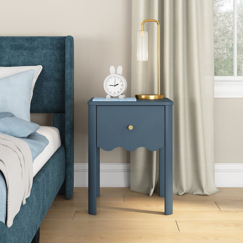 Blue nightstand bedside table with gold lamp and white bunny alarm clock beside teal upholstered bed in contemporary bedroom with beige curtains