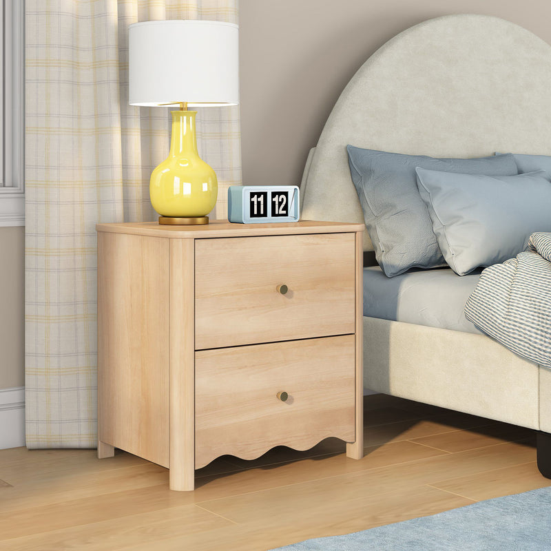 Light wood two-drawer nightstand with yellow ceramic lamp and retro flip clock beside beige upholstered bed with blue pillows