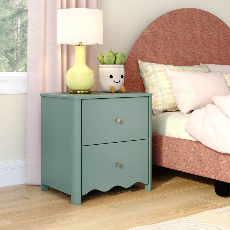 Teal two-drawer nightstand with yellow table lamp and smiling succulent planter next to a pink upholstered bed, modern pastel bedroom decor