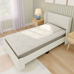 Single bed with modern headboard, white mattress, and bedside table in a stylish bedroom with striped wallpaper.