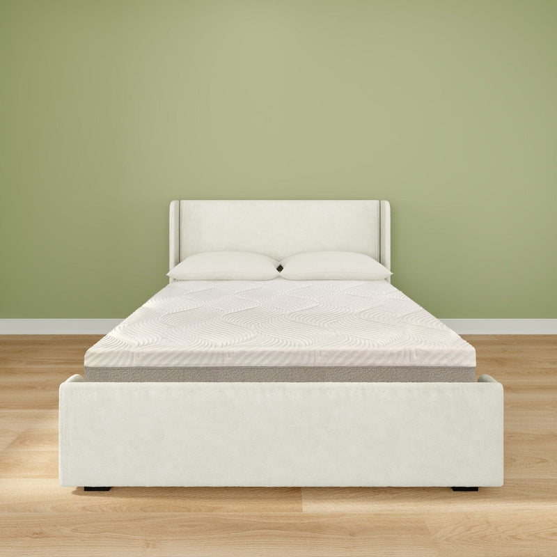 Minimalist modern bedroom interior with white upholstered bed frame, mattress and two pillows on light hardwood floor against a sage green accent wall