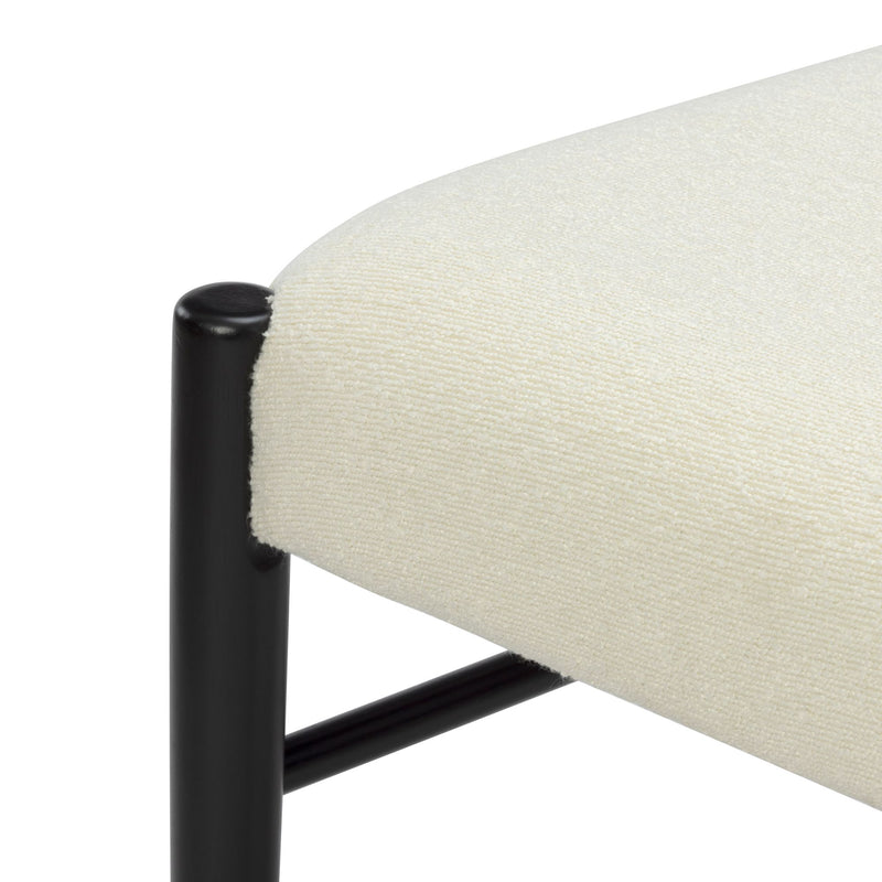 Close-up of cream boucle upholstered bench seat showing textured fabric and black metal leg