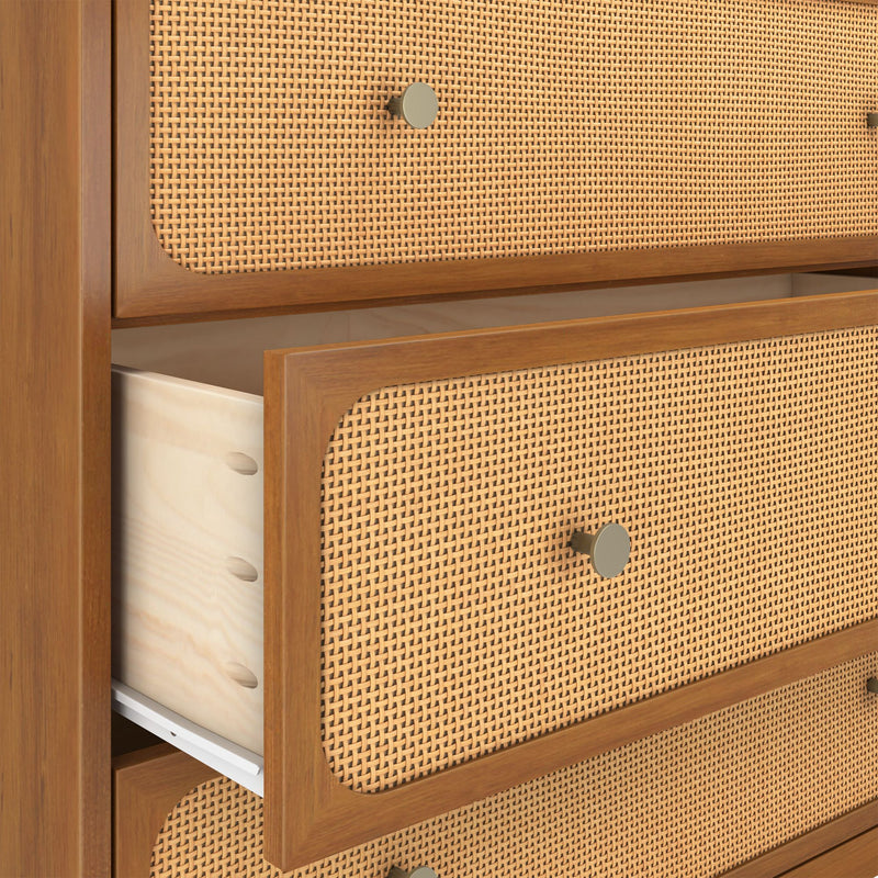 Mid-century modern wooden dresser with woven rattan cane drawer fronts, round brass knobs, and a partially open drawer revealing light wood interior and metal drawer slide