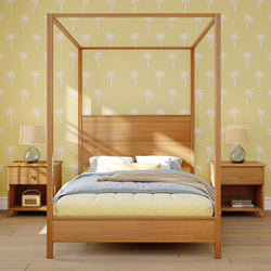 Tropical-themed bedroom with wooden canopy bed, palm tree wallpaper, and matching bedside tables with lamps.