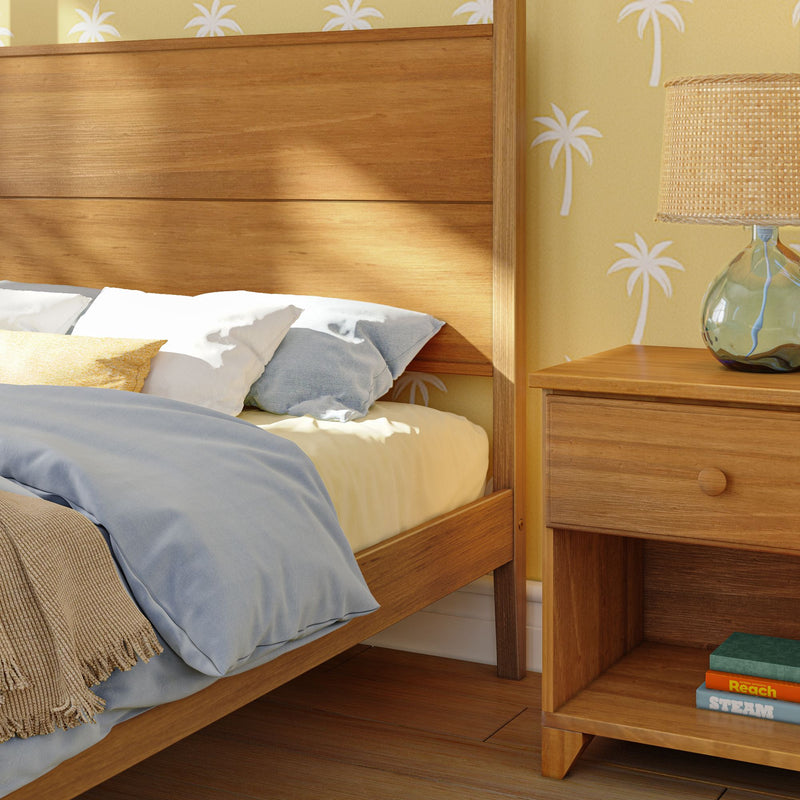 Cozy bedroom with wooden bed and nightstand, complementing a tropical wallpaper design.