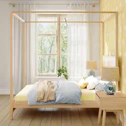 Contemporary bedroom with sunny yellow accents, canopy bed, and natural wood furniture near large window.