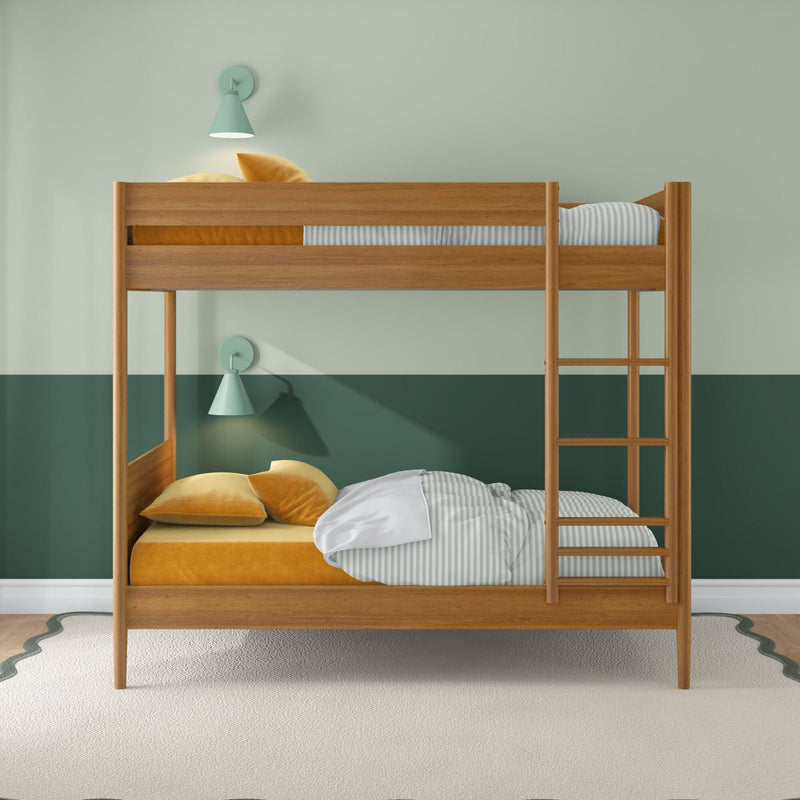 Modern wooden bunk bed in children's room with green two-tone walls, mustard velvet pillows, striped sheets, ladder and mint wall lamps