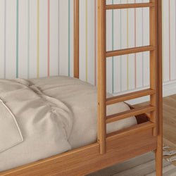 Wooden ladder bunk bed with beige bedding in colorful striped room.