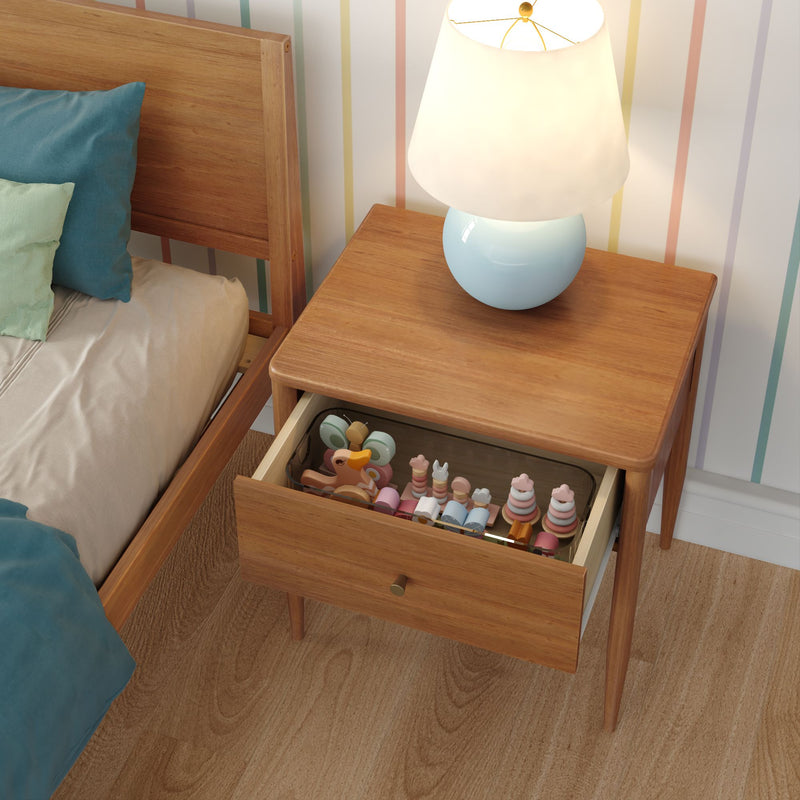 Mid-century modern wooden bedside table with blue ceramic lamp and open drawer of pastel wooden children's toys in a striped nursery bedroom
