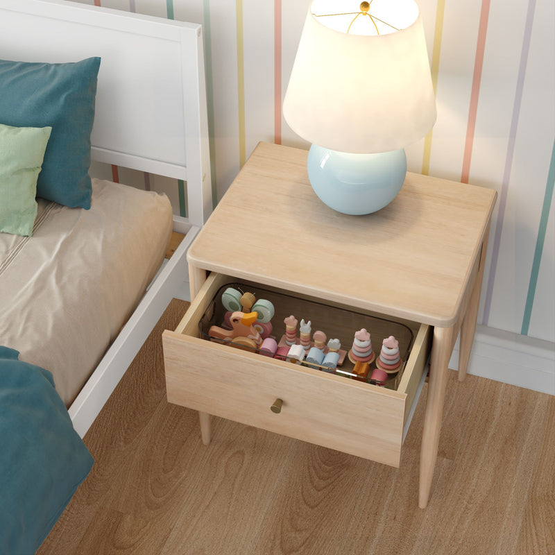 Kids bedroom nightstand with blue ceramic table lamp, open drawer of wooden toys, beige bedding and pastel striped wallpaper