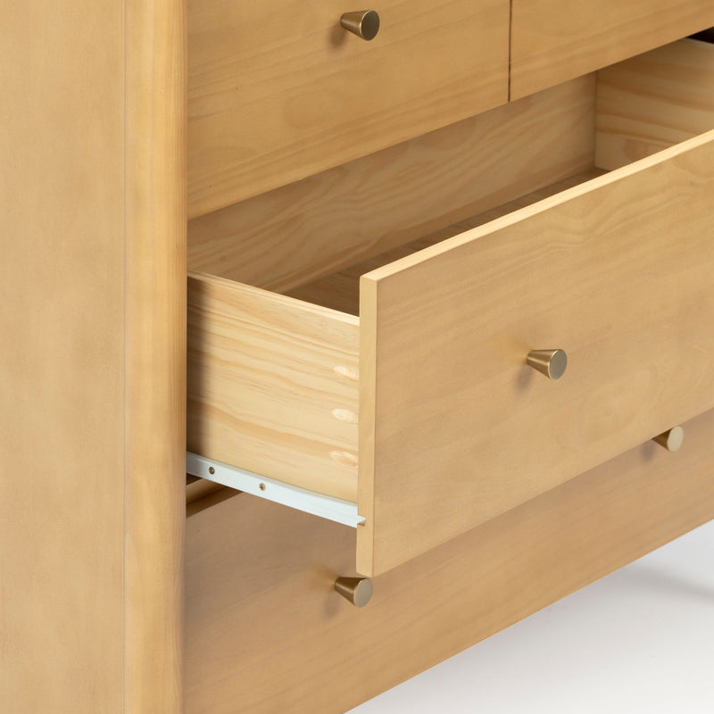 Close-up of an open light wood dresser drawer with visible dovetail joints and brass knob, natural wood grain bedroom storage chest of drawers