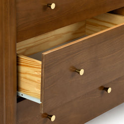 Walnut-finish dresser with brass knobs and open drawer revealing pine interior — modern bedroom storage furniture