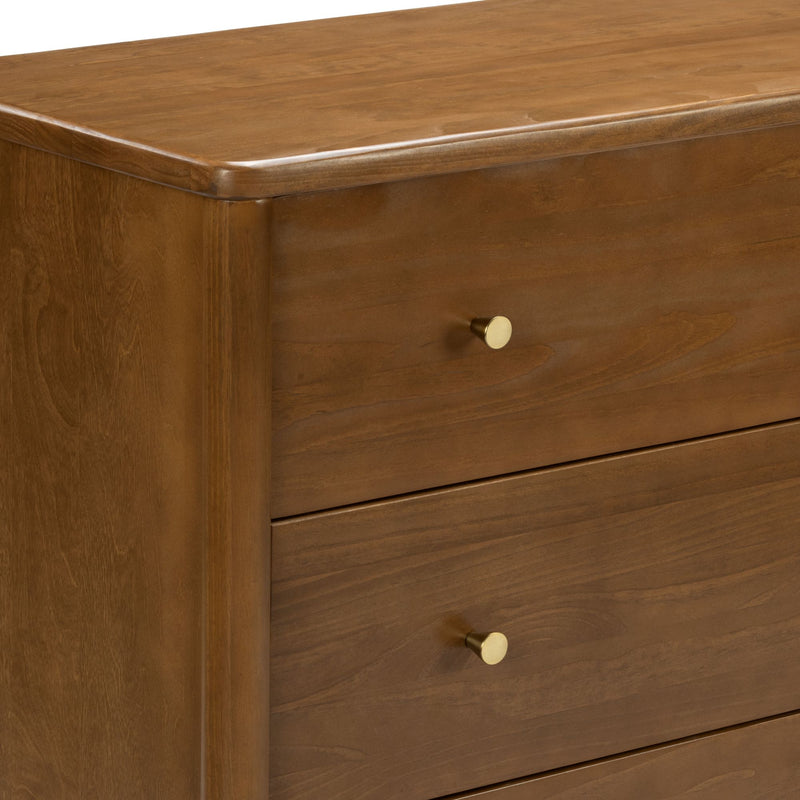 Mid-century modern walnut dresser close-up showing smooth wood grain, rounded edges and brass knob drawer pulls