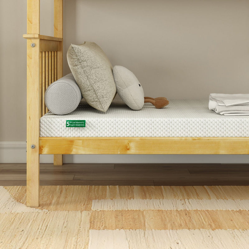 5-inch gel memory foam mattress on light wooden twin bed frame with textured cream pillows, bolster and folded white sheets in a minimalist beige bedroom