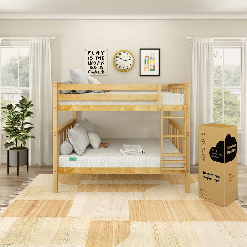 Twin-over-twin pine bunk bed in a bright kids' bedroom with a mattress-in-a-box memory foam, neutral bedding and pillows, ladder, wall clock and framed art, potted plant and sheer window curtains.