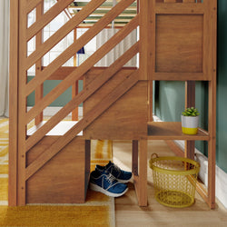 Children's wooden loft bed with built-in staircase storage and shelves, blue sneakers, yellow wire basket and potted succulent in bright bedroom