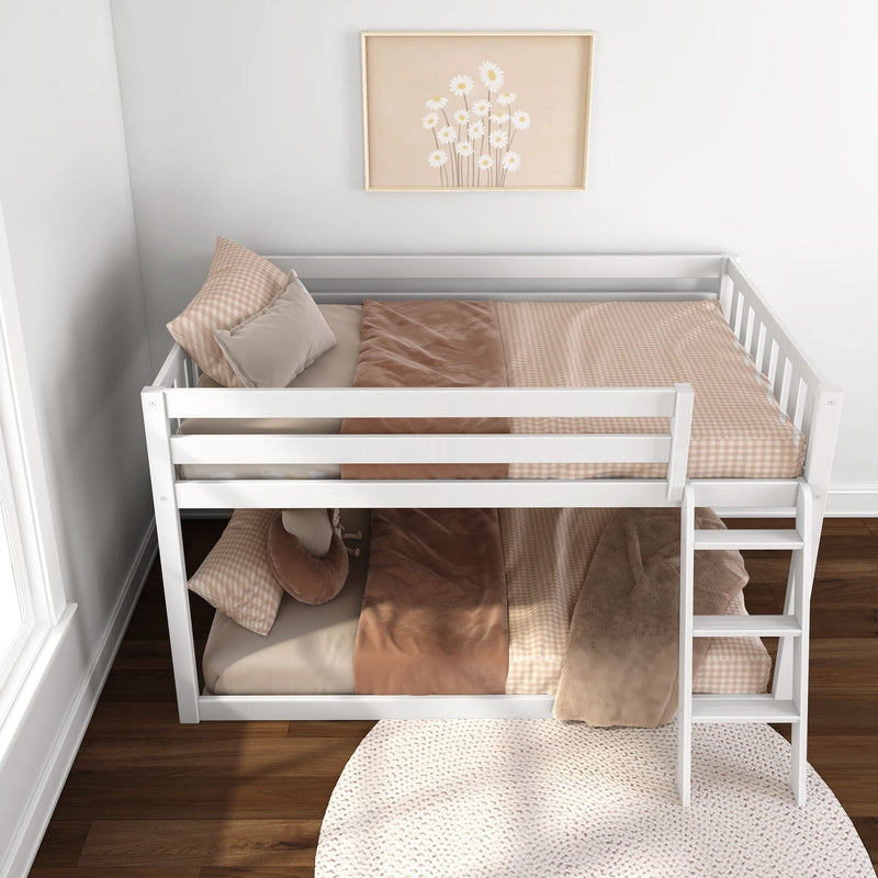 White twin-over-twin wooden bunk bed in a neutral children's bedroom with blush gingham bedding, soft throw blanket, ladder and framed daisy wall art