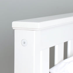 White wooden bed frame corner detail showing smooth finish and sturdy construction for bedroom furniture design.