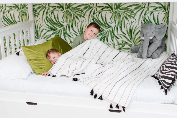 2 brothers snuggling on twin over full bunk bed with stairs Safari themed room