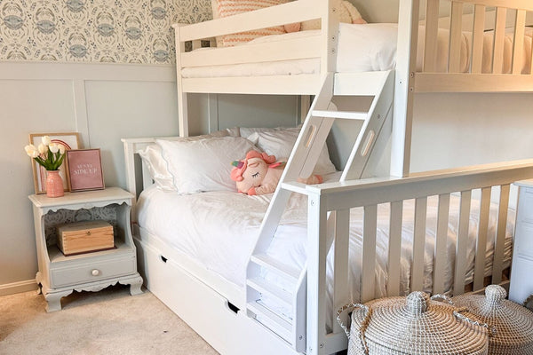 White twin over full bunk bed with trundle, pink chair, baskets, blue nightstands, and blue crab wallpaper