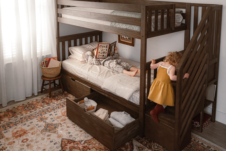 Twin over twin storage bunk bed with kid climbing up stairs