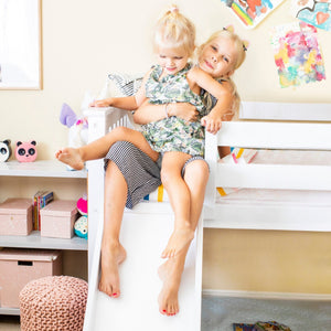 White low bunk bed with kids sliding down