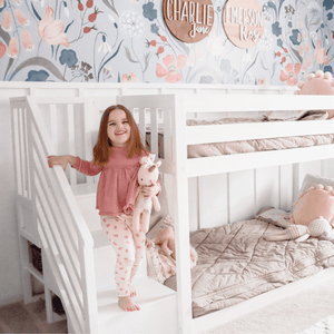 Low bunk bed in white with stairs in colorful girls room