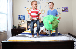 Dark brown bed frame with kids jumping on mattress