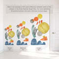 Abstract watercolor wall decals size comparison showing small, medium and large kits on a white wall — colorful yellow circles, orange and gray dots, teal arches and blue hill shapes, peel-and-stick nursery and kids room mural next to white door