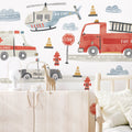 Watercolor children's room wallpaper featuring a red fire truck, ambulance, police car and rescue helicopter with stop signs, fire hydrants and traffic cones — nursery transportation mural wall decal